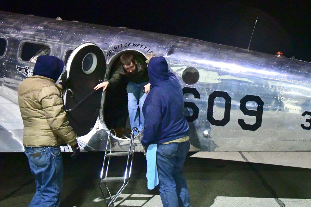 Chilly and windy...a typical west Texas evening.  Lyle Thornton (L) and Paul Cooper assist a passenger from the C-45 after a flight.